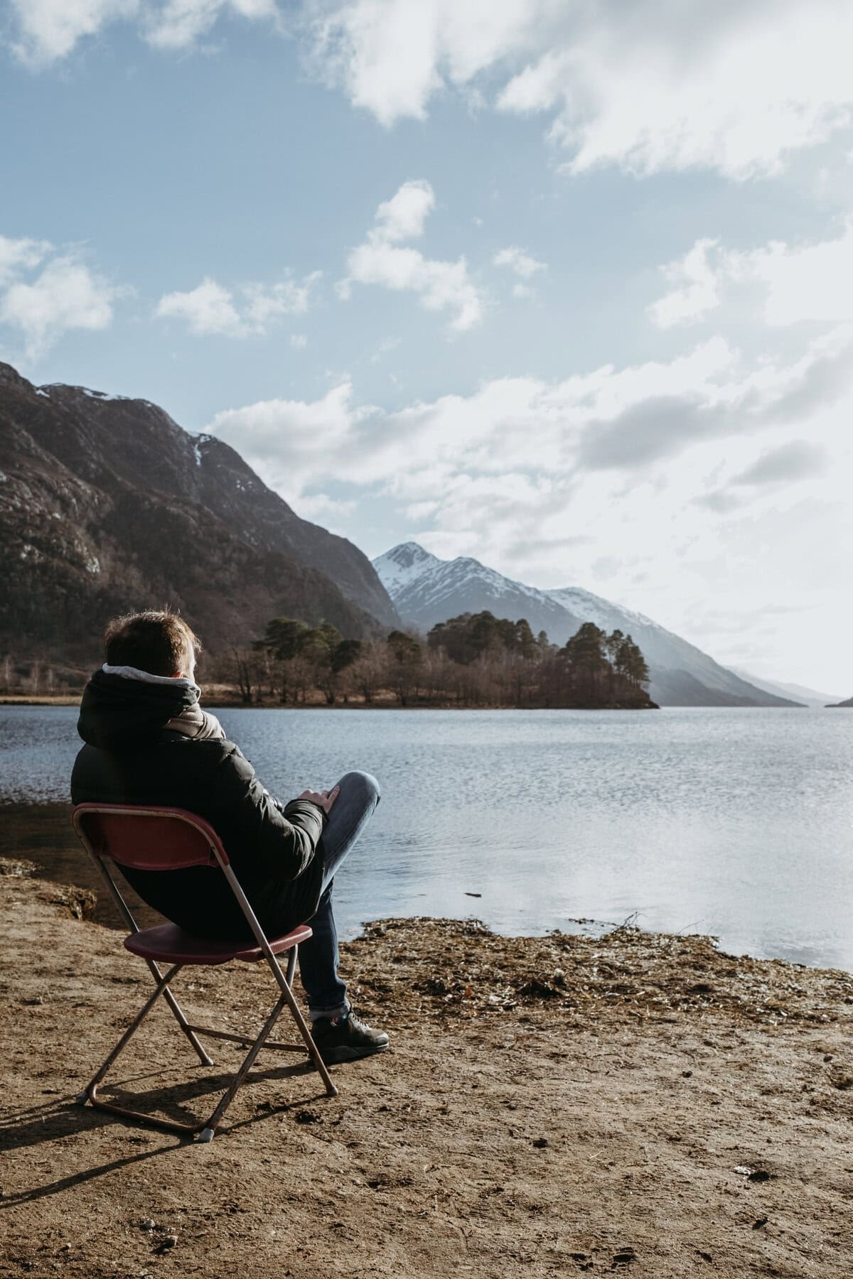 _Man Sitting in a Chair, Relaxing on Loch Shiel, Glenfinnan, Inverness Shire, Scotland, on a Cold Spring Sunny Day
